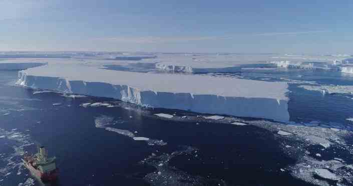 Ein Forschungsschiff im Wasser am Rande des östlichen Thwaites-Schelfeises in der Antarktis.