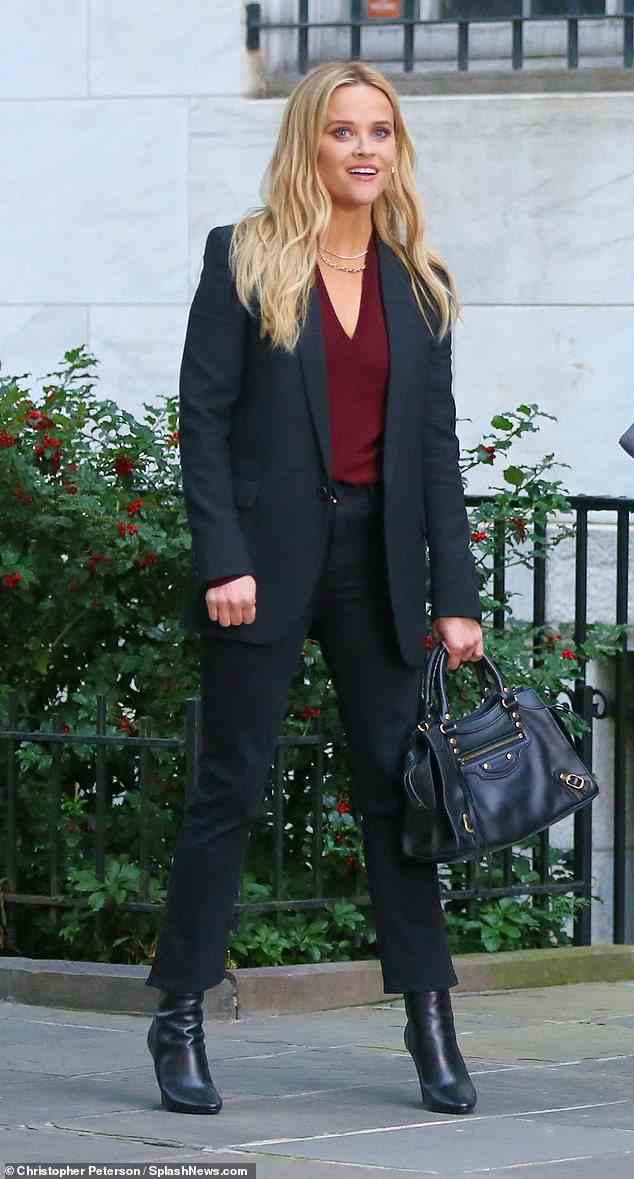 Business-Chic: Stylisten für die Kostümabteilung waren genau richtig, als sie Witherspoon in einen schwarzen Anzug mit einem burgunderroten Oberteil und schwarzen Lederstiefeln kleideten