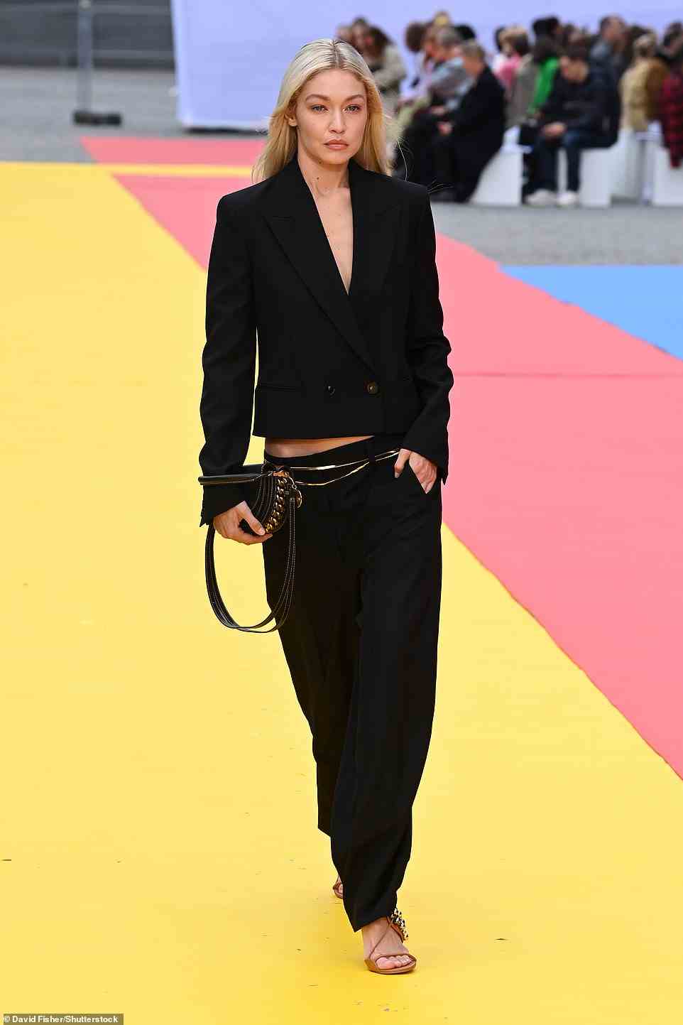Sophisticated: Over on the runway, Gigi looked sensational as she slipped into an all-black ensemble, donning a tailored black plunging blazer