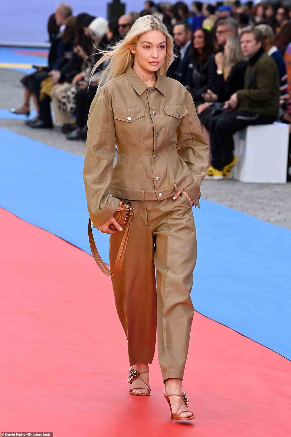 Stylish: Gigi later changed outfits as she strutted down the runway once again, donning vegan leather trousers with a matching khaki jacket