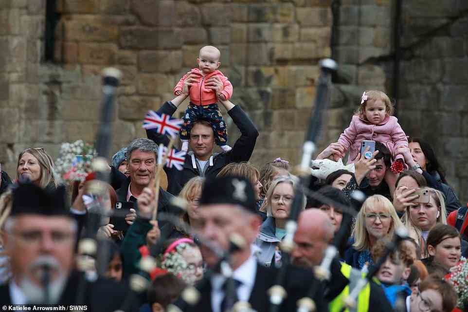 Children are lifted on to the shoulders of their parents as they watch the festivities in Dunfermline