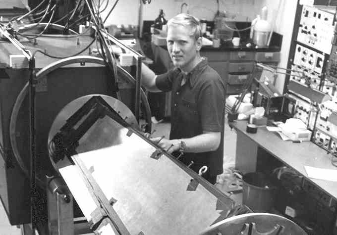 Schwarz-Weiß-Bild von John Clauser bei der Arbeit in einem Labor