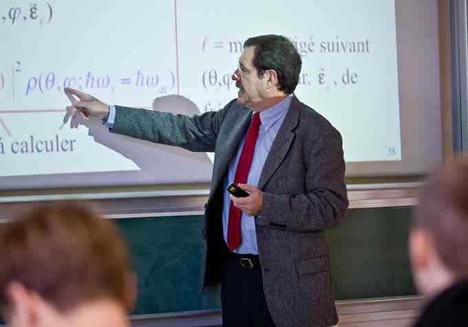 Alain Aspect zeigt auf eine Gleichung auf einer Projektionsleinwand