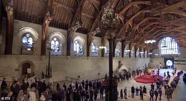Sich in die Schlange einreihen: Mitglieder der Öffentlichkeit können gesehen werden, wie sie sich anstellen, um in die Westminster Abbey zu gelangen, und die Medienbox ist auf der Rückseite zu sehen