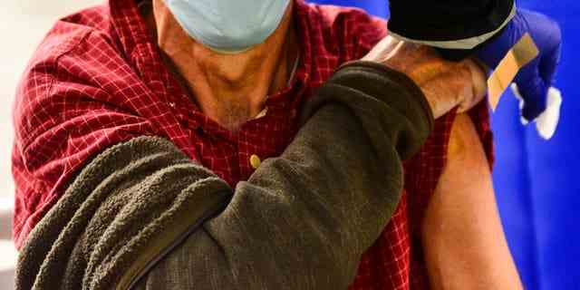 DATEI – Ein Mann erhält am Dienstag, den 26. Oktober 2021, in Brattleboro, Vt., eine Grippeimpfung. Ärzte haben eine Botschaft für impfmüde Amerikaner: Lassen Sie Ihre Grippeimpfung diesen Herbst 2022 nicht aus. Und zum ersten Mal, Senioren werden dringend gebeten, eine spezielle extra starke Sorte zu kaufen. 