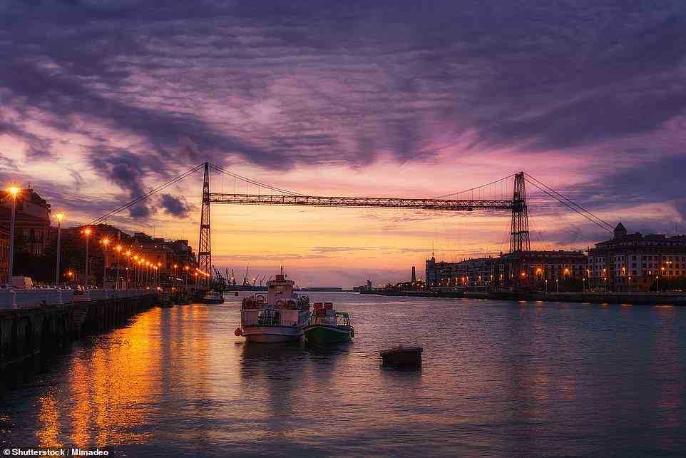 Beobachten Sie den Sonnenuntergang über der abgebildeten Vizcaya-Brücke, der ältesten Schwebefähre der Welt und UNESCO-Weltkulturerbe