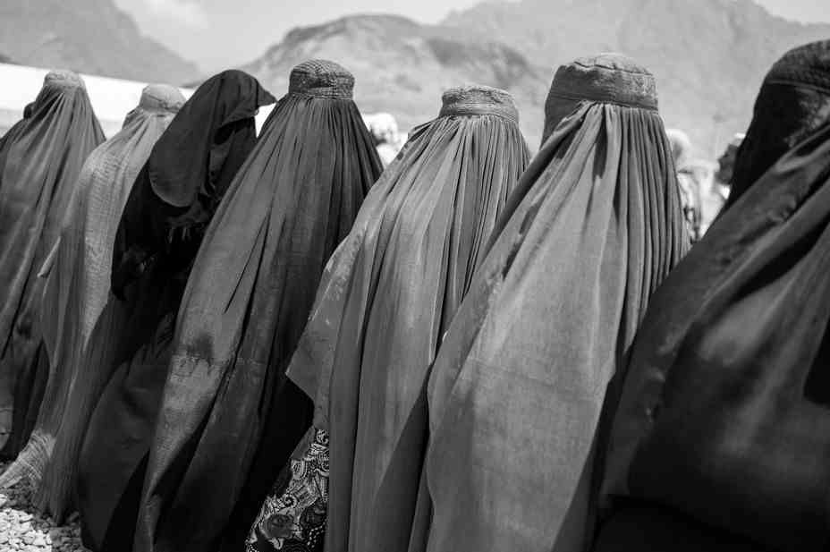 Bild von Flüchtlingsfrauen, die in einer Schlange stehen, um sich auszuweisen und Bargeld zu erhalten, wenn sie nach Hause in den Osten Afghanistans zurückkehren.