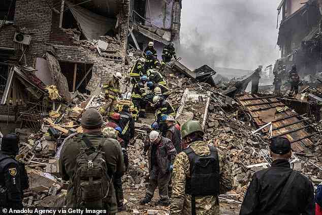 Einsatzkräfte durchsuchen die Ruinen eines Hauses in Saporischschja, einer Stadt in der Südukraine, die über Nacht weiterhin bombardiert wurde