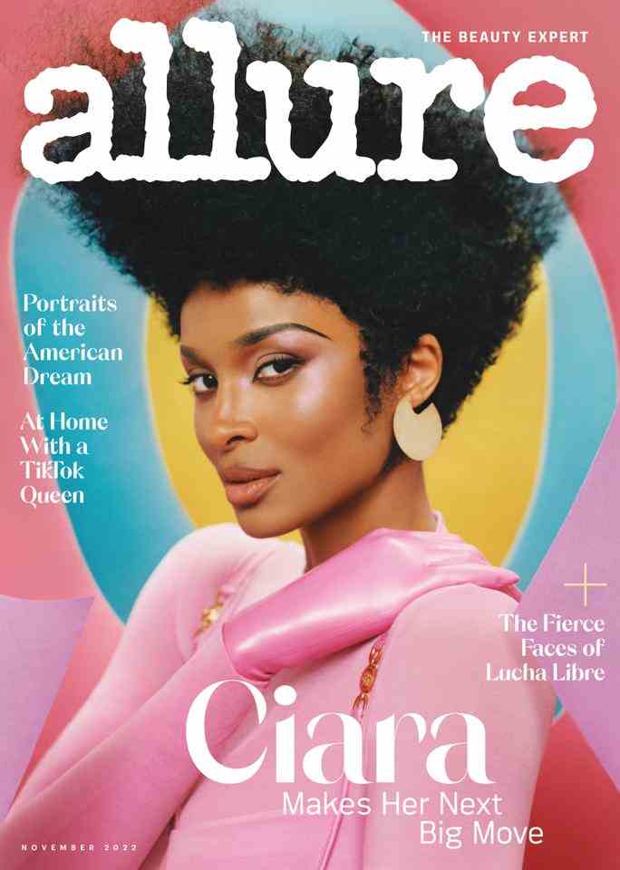 Ciara on the cover of Allure magazine in an ‘80-style portrait. Her hair is styled into a tall flattop and she wears a pink top, pink gloves, and pink makeup. 