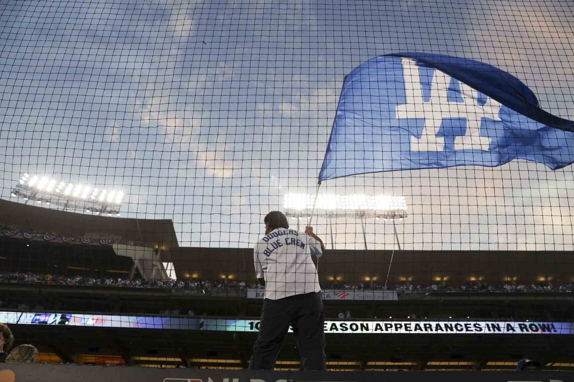 Die blaue Crew der Dodgers schwenkt vor dem ersten Spiel eine Flagge.