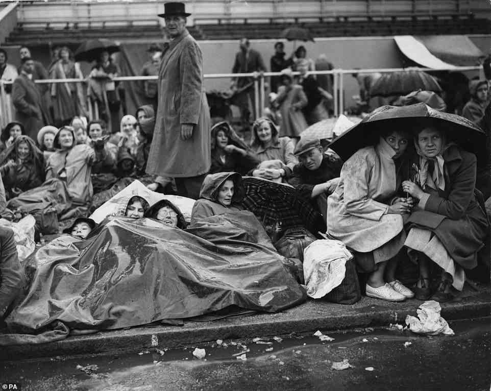Royal fans wait on The Mall in London in the rain on June 1, 1953 for an all-night vigil ahead of Queen Elizabeth II's coronation