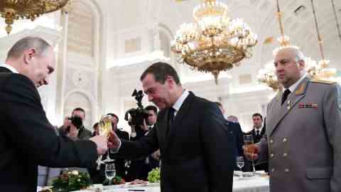 Wladimir Putin (links) stößt mit dem damaligen Ministerpräsidenten Dmitri Medwedew neben Sergej Surovikin an, nachdem am 28. Dezember 2017 Militärangehörigen, die in Syrien gekämpft haben, staatliche Auszeichnungen verliehen wurden.