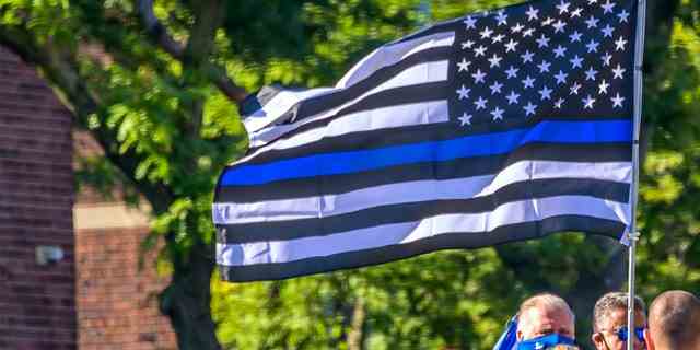 Pro-Polizei-Demonstranten tragen bei einem Protest eine Blue Lives Matter-Flagge.