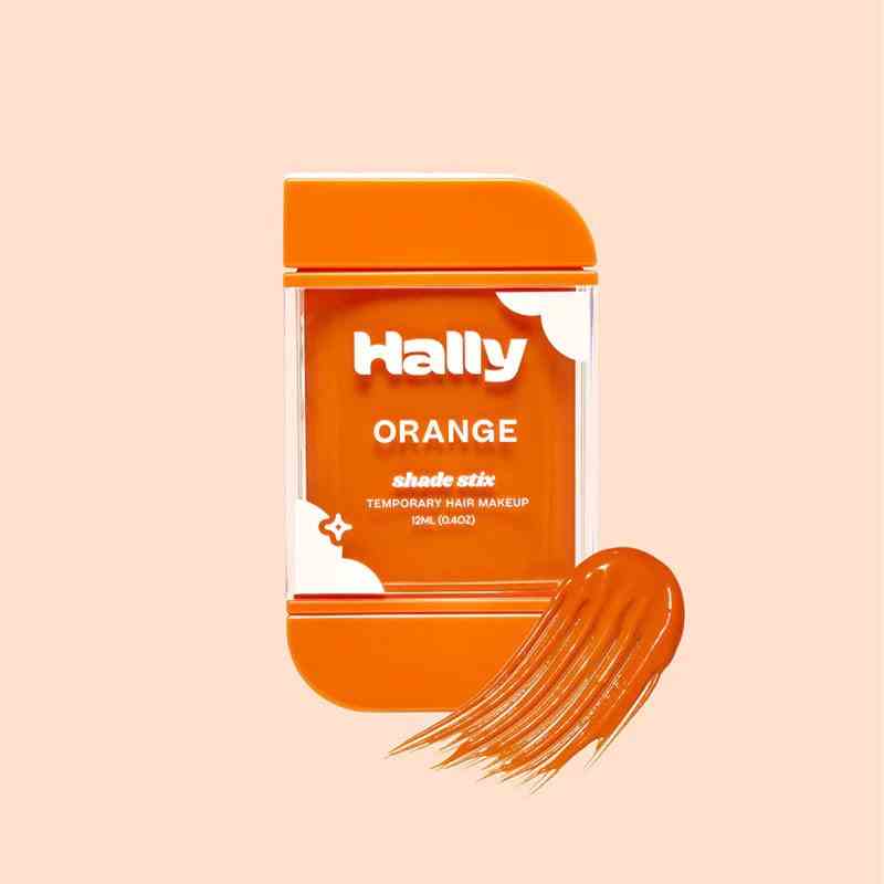Hally Hair Shade Stix orangefarbener Haar-Make-up-Stick auf hellorangefarbenem Hintergrund