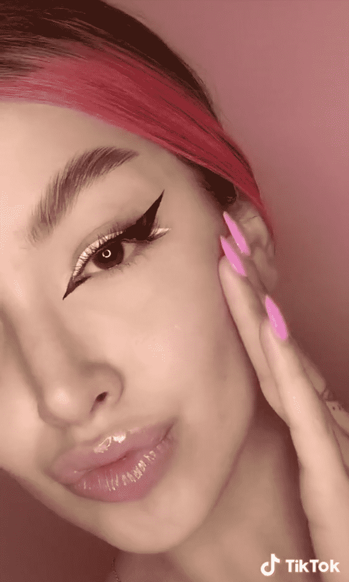Ein Selfie einer Frau mit weißem und schwarzem Cateye-Make-up.