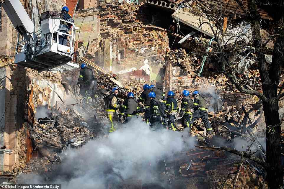 Rescuers sort through the rubble of a residential building hit by Russian kamikaze drones as explosions rock Ukraine's capital during a drone attack in the early morning on October 17