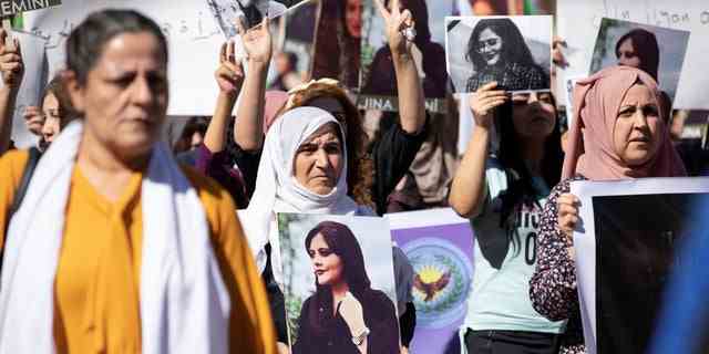 Frauen tragen Bilder während einer Protestaktion gegen den Tod der 22-jährigen Kurdin Mahsa Amini im Iran in der von Kurden kontrollierten Stadt Qamischli im Nordosten Syriens am 26. September 2022.  