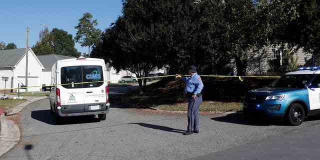 Ein Polizeibeamter aus Raleigh erlaubt einer Person, auf dem Sahalee Way nach Hause zurückzukehren, der nach einer Schießerei in Raleigh, NC, am Freitag, den 14. Oktober 2022, mit Ausnahme von Anwohnern geschlossen bleibt. 