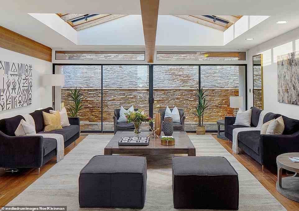 The modernist mansion even includes a sleek stone 'conversation pit centered by a bold steel-clad fireplace, adjacent to the formal dining area and wet bar', according to the listing