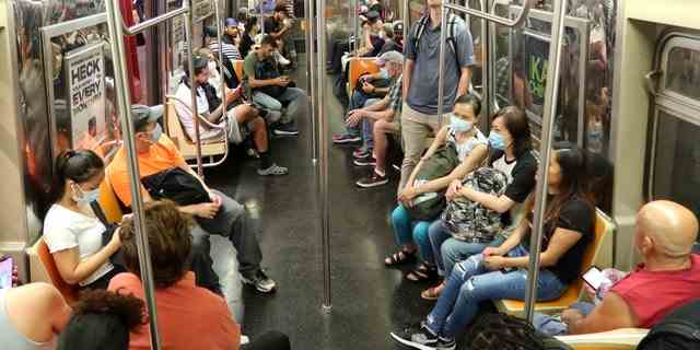 Menschen fahren am 15. Juli 2022 in New York City in einem U-Bahn-Wagen der Linie F. 