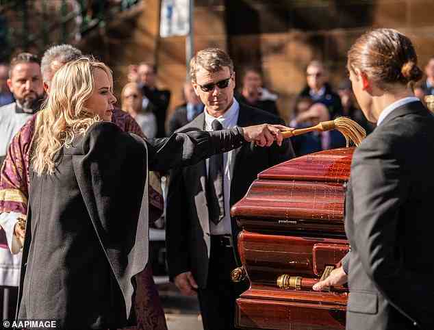 Kristie Fulton putzt den Sarg von Bob Fulton, ihrem verstorbenen Vater, während seines Staatsbegräbnisses im Juni 2021