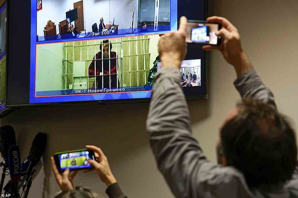 WNBA star and two-time Olympic gold medalist Brittney Griner is seen on the bottom part of a TV screen as she waits to appear in a video link provided by the Russian Federal Penitentiary Service a courtroom