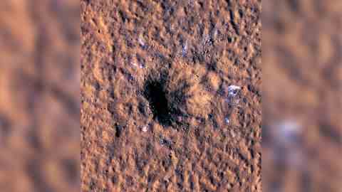 Felsbrockengroße Eisbrocken sind um und außerhalb des Randes des neuen Kraters verstreut zu sehen.