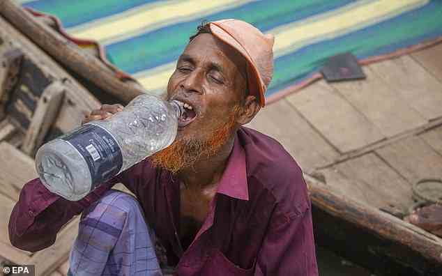 Die Studie ergab auch, dass die ärmsten und am wenigsten kohlenstoffausstoßenden Länder der Welt die größten wirtschaftlichen Rückschläge erlitten haben, beispielsweise in den Tropen.  Im Bild: Ein Bootsmann trinkt an einem heißen Tag im April in Dhaka, Bangladesch, aus einer Wasserflasche