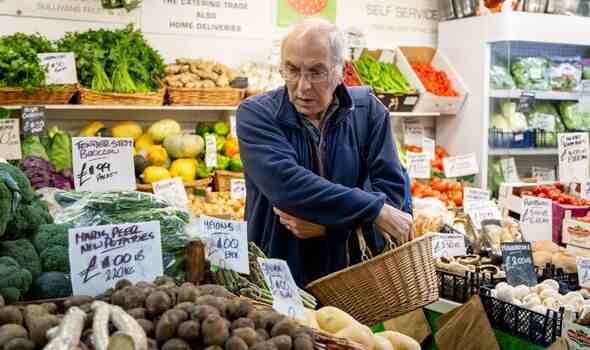 Ein Mann kauft in einem Gemüsehändler in Cardiff Market ein