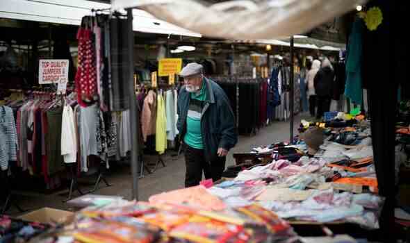 Ein Mann geht am 27. Oktober 2022 in Wolverhampton durch den Outdoor-Markt von Bilston