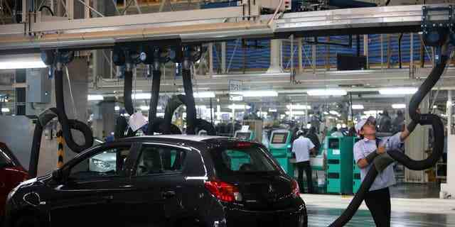 DATEI – Ein Mitarbeiter von Mitsubishi Motors Corp. bedient Geräte an der Produktionslinie des Mirage-Fahrzeugs im Werk des Unternehmens in Laem Chabang, Thailand.