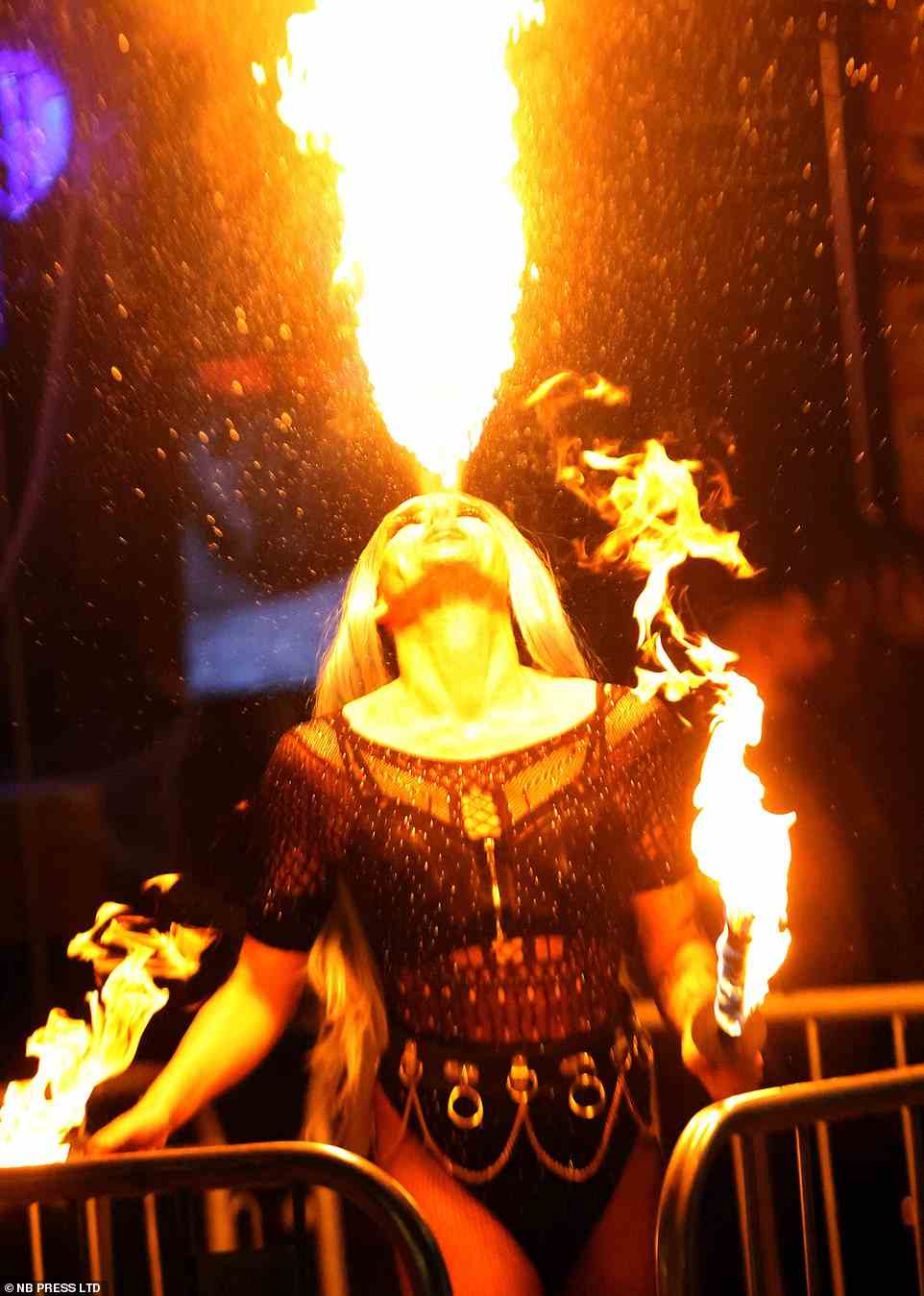 A street performer breathes a stunning plume of fire into the air on the streets of Leeds late on Friday night