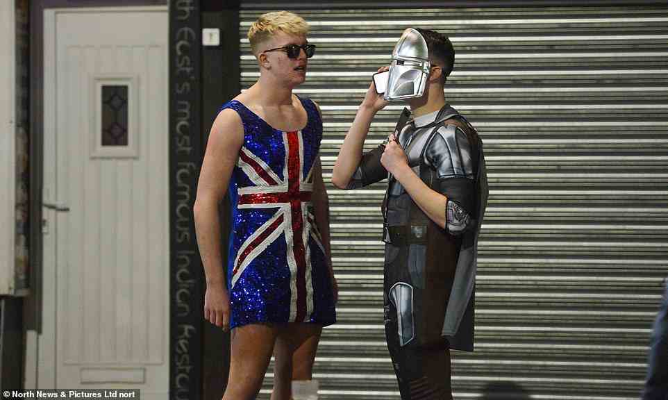 Men dressed as a Union Jack and a Star Wars character stand on the street in Newcastle on Friday night