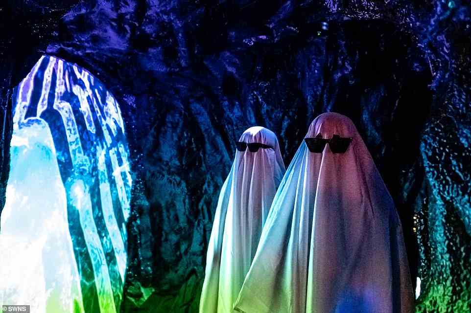 Attendees dressed as ghosts with sunglasses surrounded by neon lights join the party at Wake The Tiger