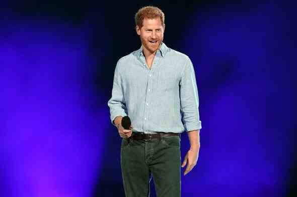 Prinz Harry hält ein Mikrofon auf der Bühne