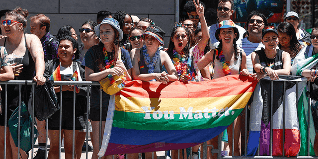 Menschen halten während der 51. LGBTQ Pride Parade in Chicago, Illinois, am 26. Juni 2022 eine Regenbogenfahne hoch. – Die Pride Parade kehrte nach einer dreijährigen Pause aufgrund der Coronavirus-Pandemie in die Stadtteile Lakeview und Uptown zurück. 