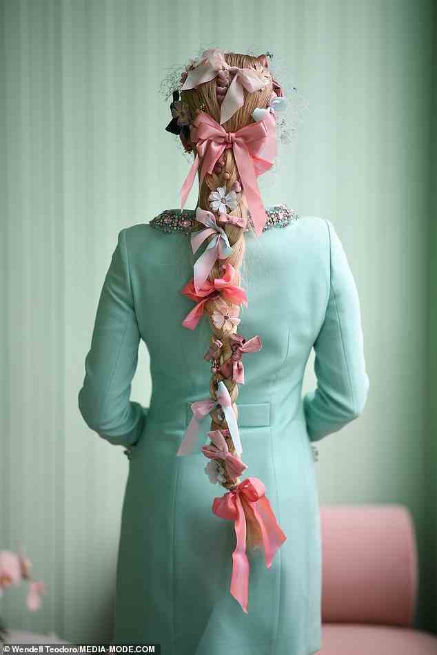 Die Fashionista schmückte ihr Haar mit einem Dutzend Schleifen und Blumen, die perfekt zu ihrem Schmetterlingsschleier passten