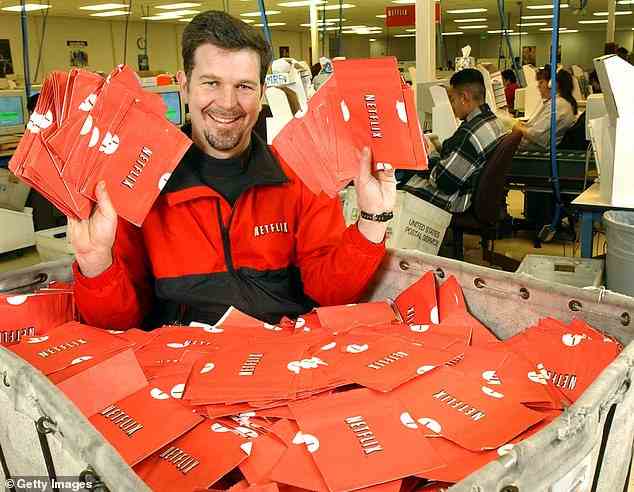 Netflix-Mitbegründer Reed Hastings sitzt 2002 in einem Wagen voller versandfertiger DVDs. Hasting schlug Blockbuster vor, sein Unternehmen für 50 Millionen Dollar zu kaufen, wurde aber abgelehnt