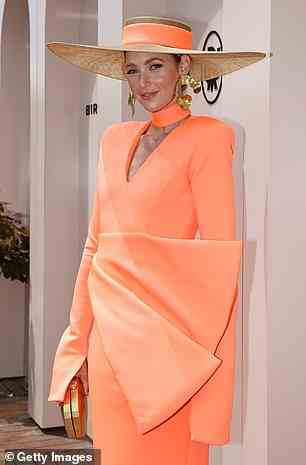 Sie trug auch einen großkrempigen Hatinator mit einem orangefarbenen Band, das perfekt zu ihrem Kleid passte