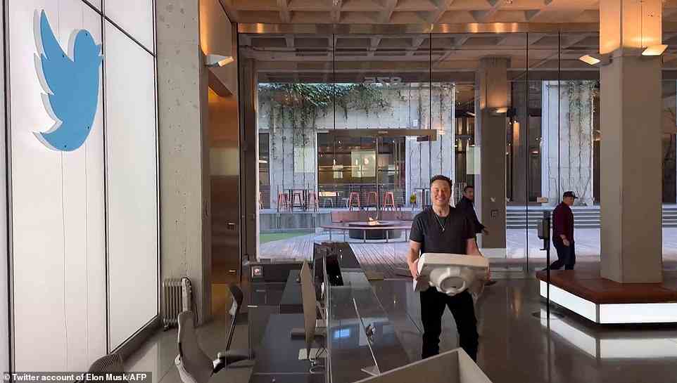 Billionaire Elon Musk carries a sink into Twitter's head office in San Francisco as he buys the social media company