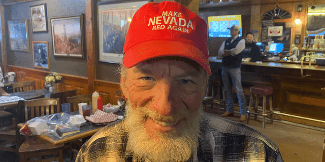 Der Wähler aus Nevada, Randall Clark, trägt einen Hut mit der Aufschrift "Machen Sie Nevada wieder rot." Clark nahm am 2. November an einer kleinen Kundgebung in Eureka, Nevada, teil, einer der Haltestellen auf Laxalts Bustour.