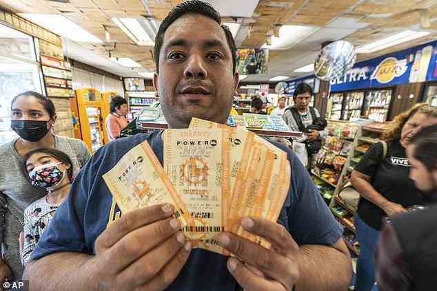 Hector Solis hält Lottoscheine hoch, die er mit seinen Kollegen für die Samstagsziehung im Bluebird Liquor Store in Kalifornien gekauft hat.  Es gab keinen Gewinner und die nächste Ziehung findet am Montag statt