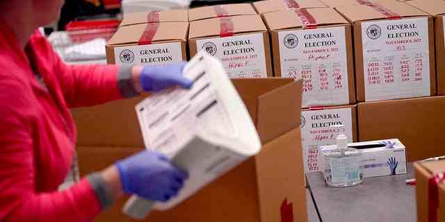 Ein Wahlhelfer schachtelt tabellarische Stimmzettel im Maricopa County Recorders Office, Mittwoch, den 9. November 2022, in Phoenix. 