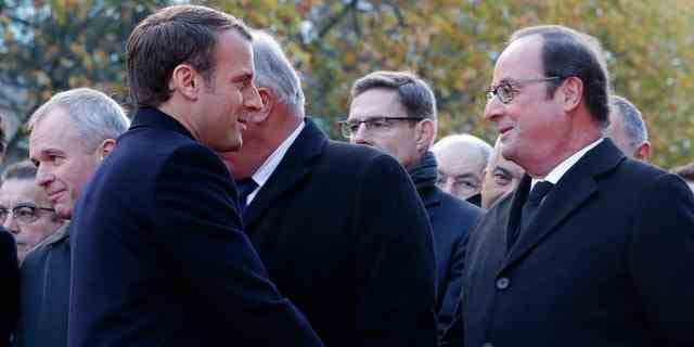 Der französische Präsident Emmanuel Macron, links, schüttelt dem ehemaligen französischen Präsidenten Francois Hollande die Hand, als sie vor einer Gedenktafel vor dem Stade de France in Saint-Denis bei Paris stehen, Montag, 13. November 2017.