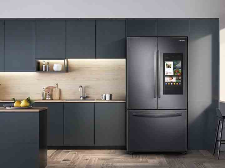 28 cu.  ft. Samsung 3-türiger French Door Kühlschrank mit Family Hub in einer Küche mit dunkelgrauen Schränken und Holzboden.