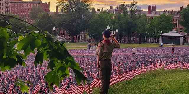 Dylan Smith aus New York grüßt in seiner Scouting-Uniform amerikanische Flaggen zum Gedenken an US-Veteranen. 
