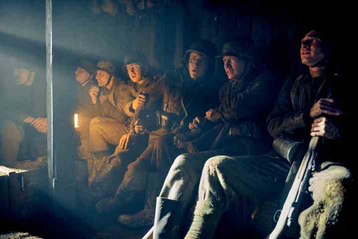 Soldaten sitzen in einem Graben in All Quiet an der Westfront.
