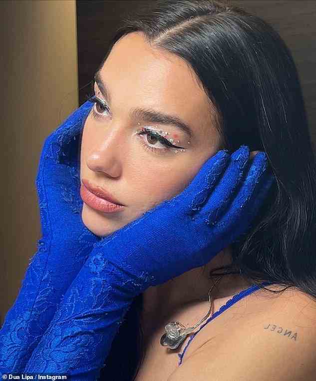 Sternenäugig: Dua zeigte ihre unglaubliche Schönheit auf einem Foto, gekleidet in ihr Performance-Outfit und ihr Gesicht mit blauen behandschuhten Händen umschließend