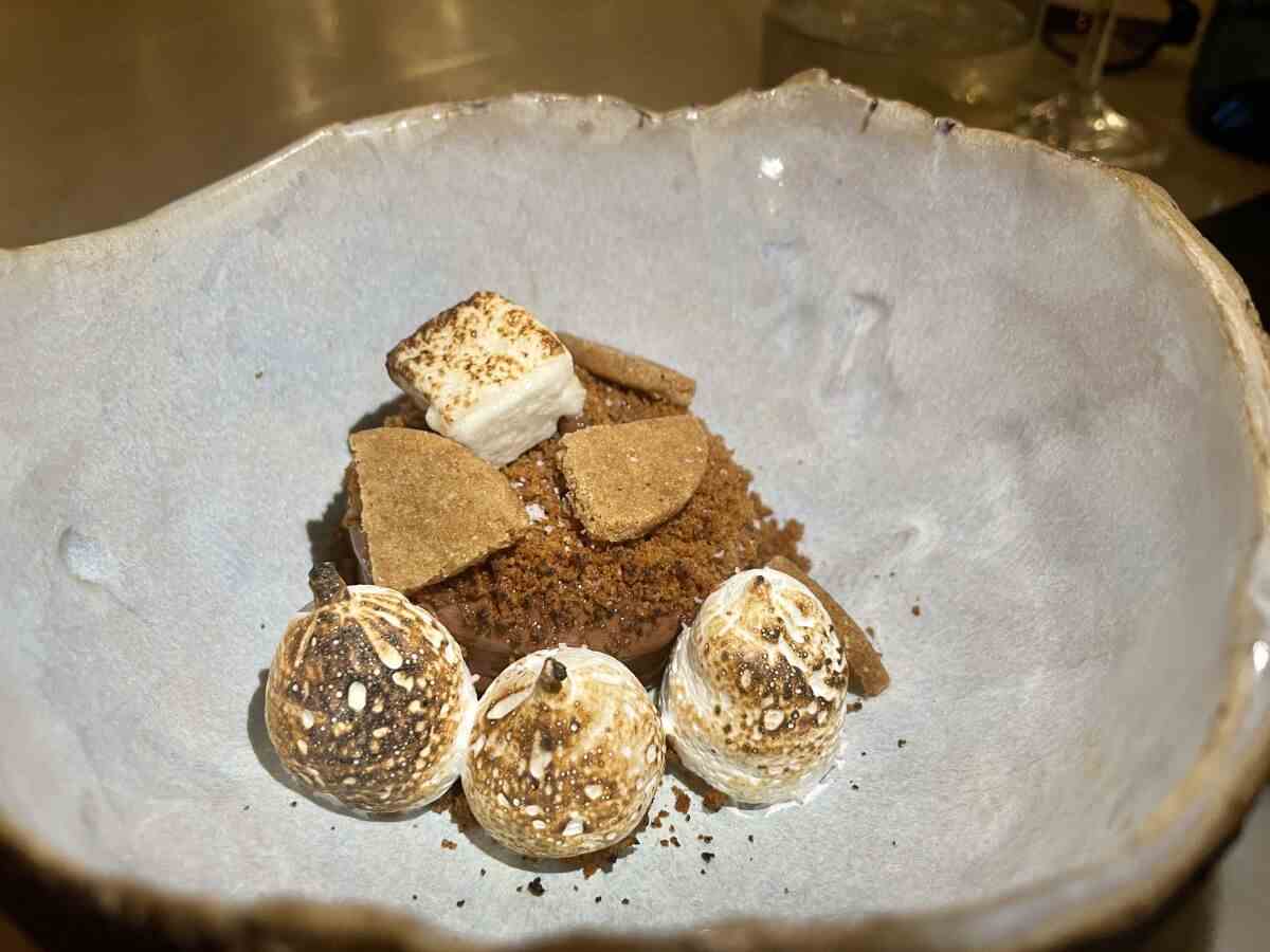 Ein Teller mit dekonstruierten S'mores mit angezündeten Marshmallows