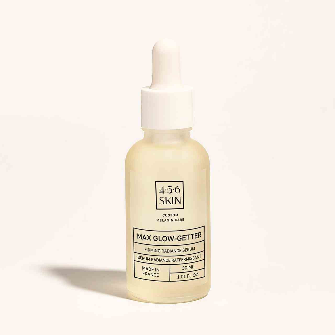 4.5.6 Skin Max Glow-Getter Firming Radiance Serum hellgelbe Serumflasche auf grauweißem Hintergrund